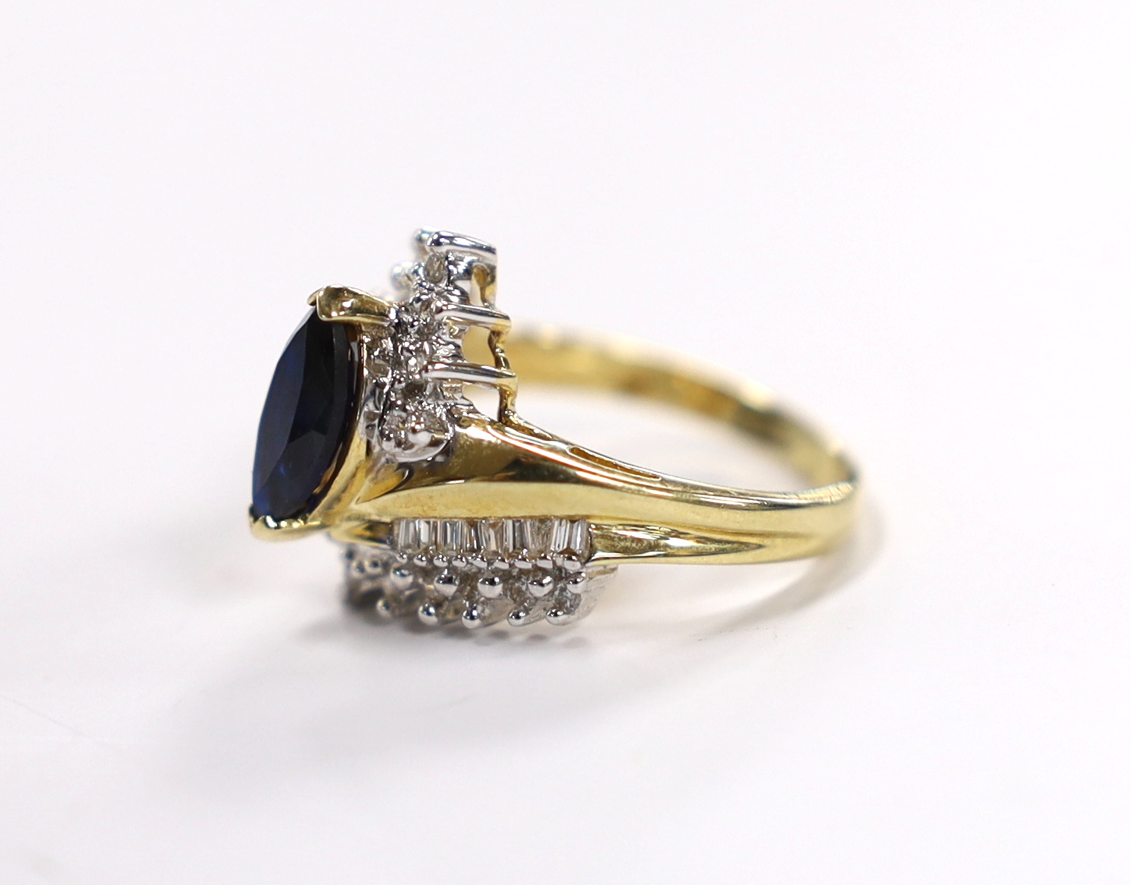 A modern 14kt, sapphire and diamond set crossover cluster ring, size M, gross weight 5.5 grams.